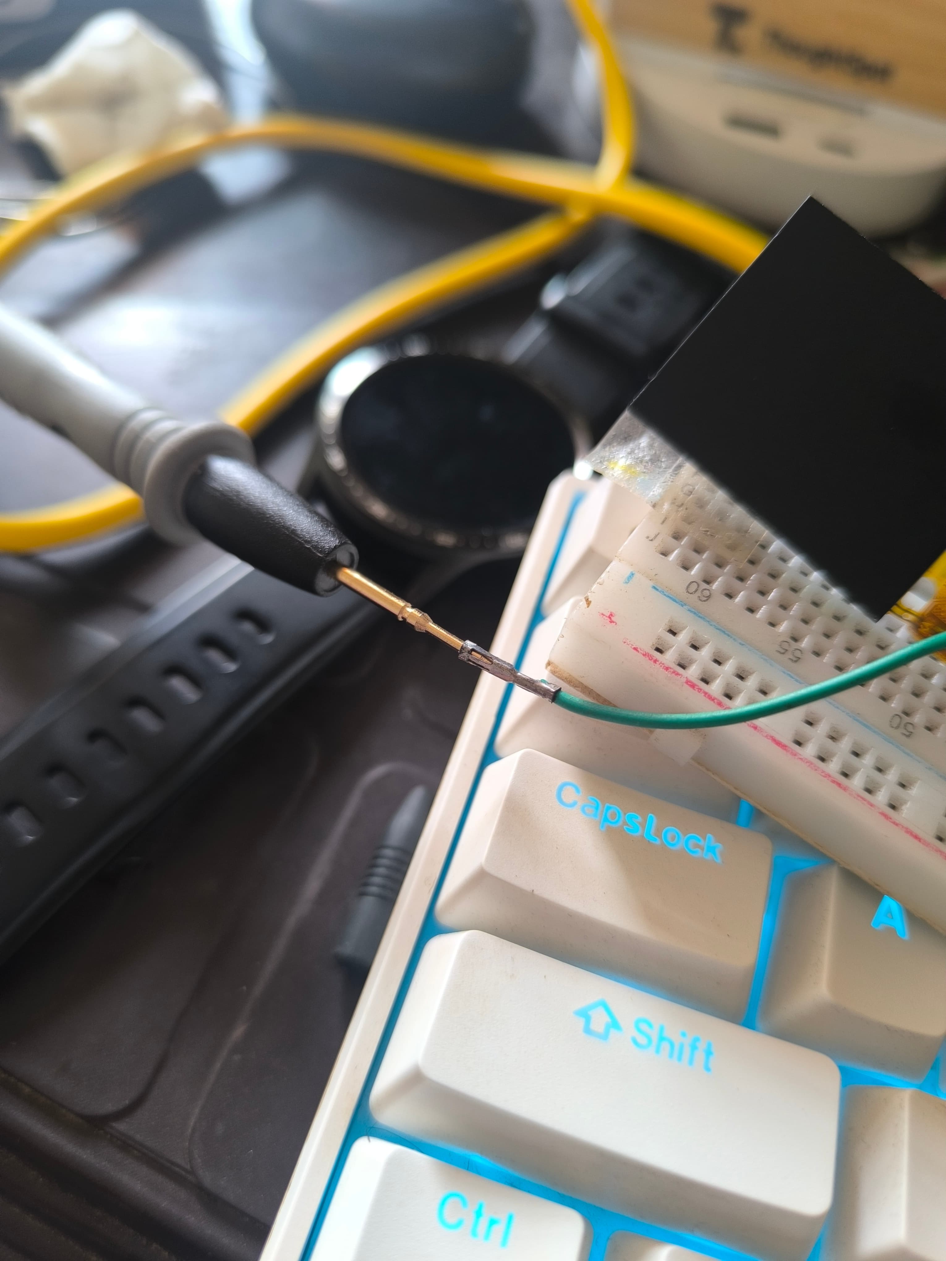 The multimeter probe clipped to the free end of the wire
